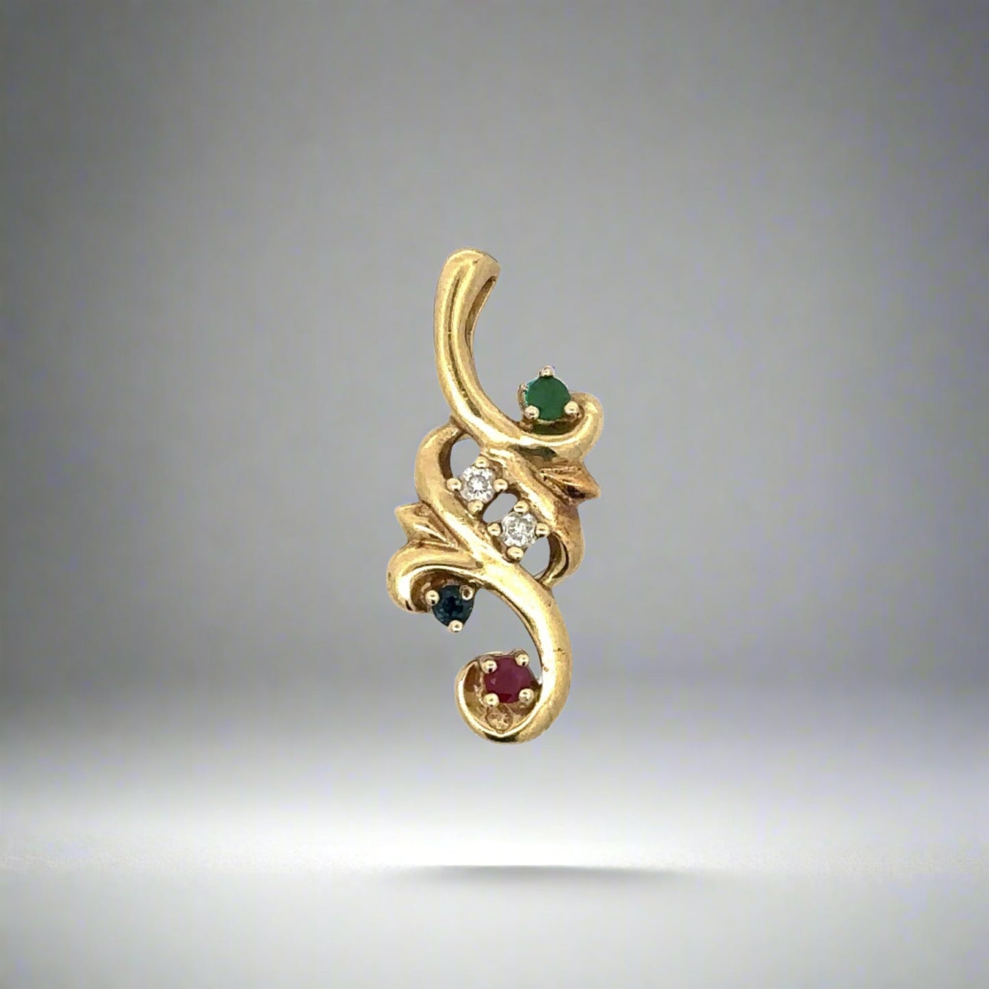 Front of yellow gold pendant with 1 small round emerald, 1 small round sapphire, 1 small round ruby, + 2 small round diamonds. Scratches on gold
