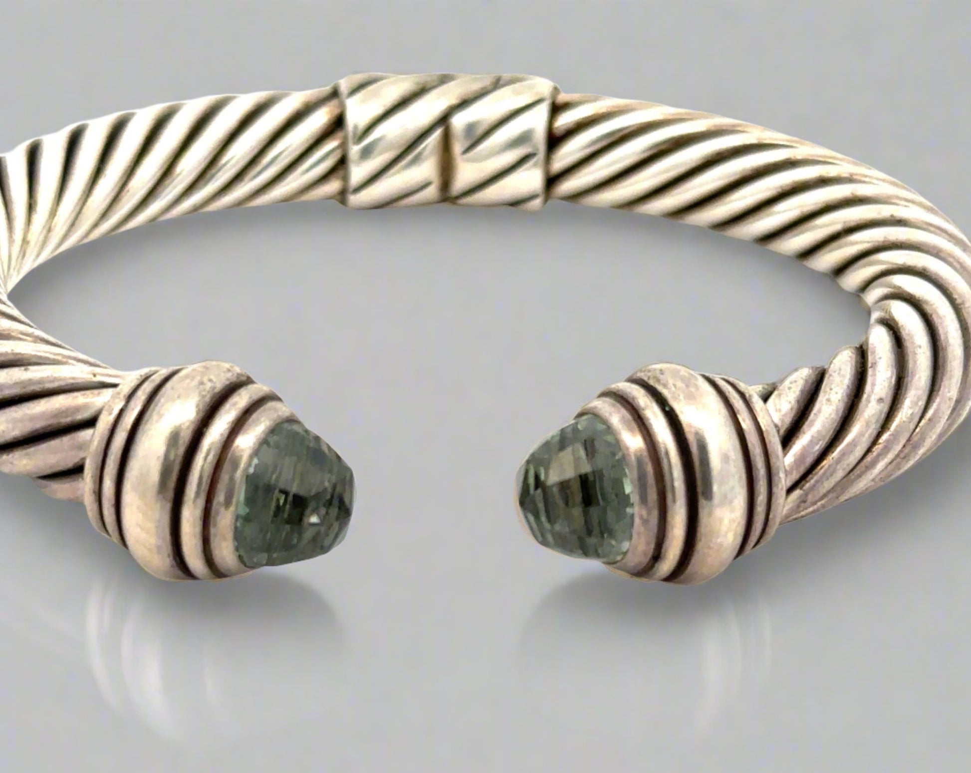 Front of open silver textured bracelet with 2 dome-shaped Prasiolite Gemstones- yellowish green color. Scratches on silver.