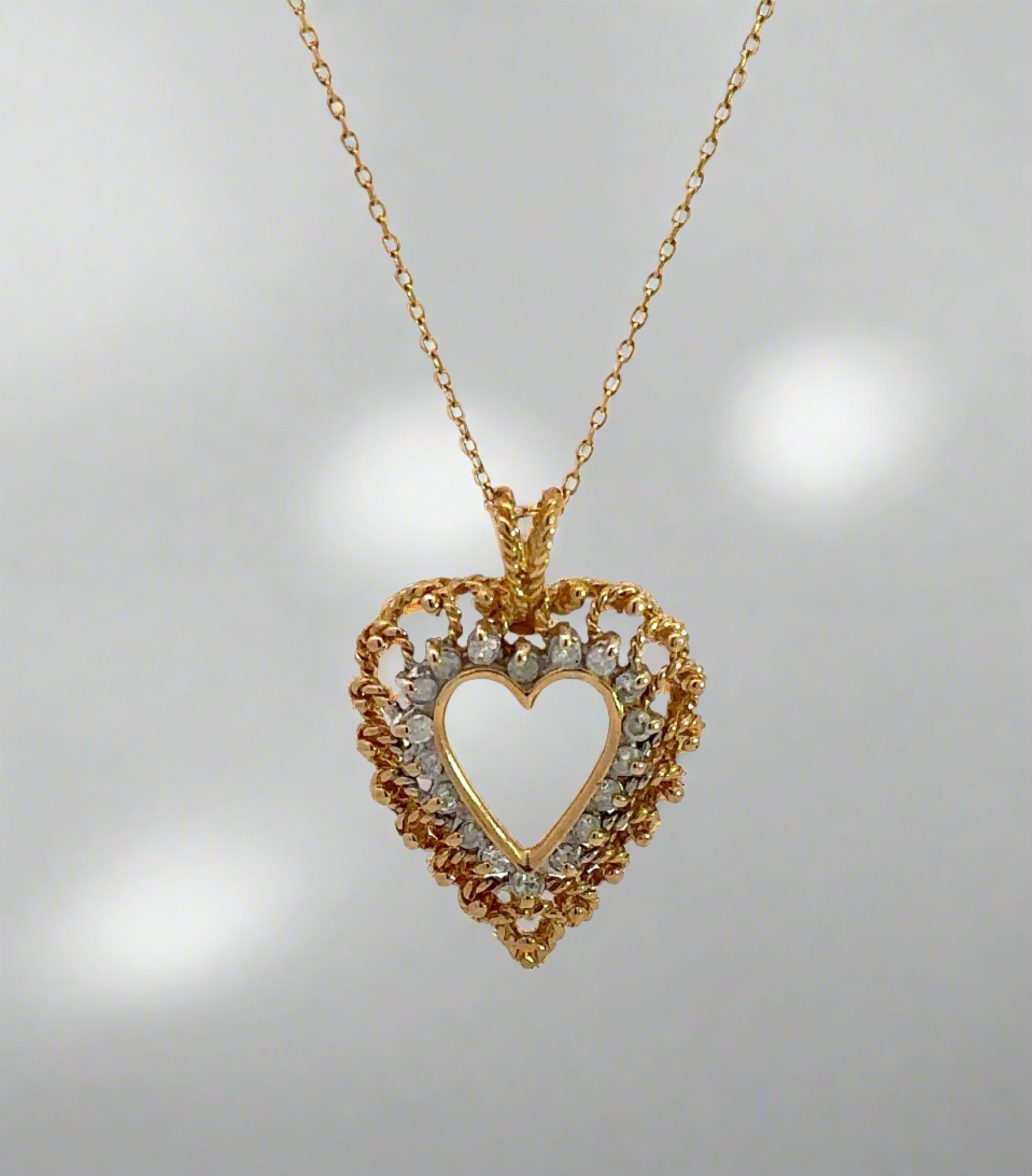 Diamond heart necklace on thin yellow gold chain with diamonds and gold in the heart outline