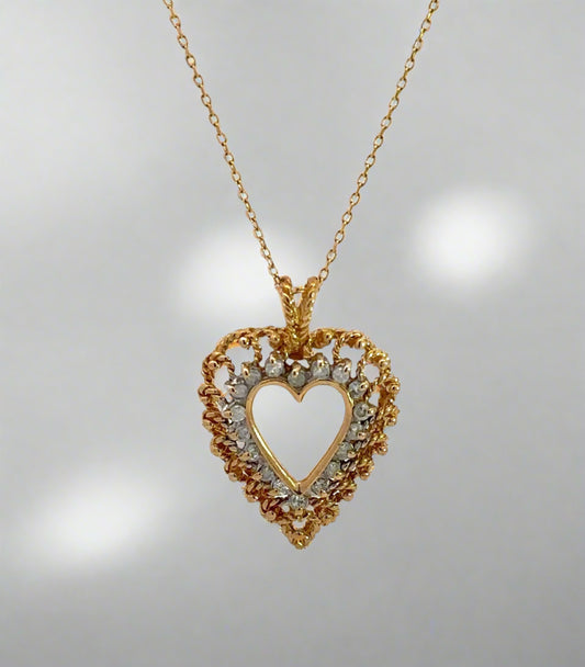 Diamond heart necklace on thin yellow gold chain with diamonds and gold in the heart outline