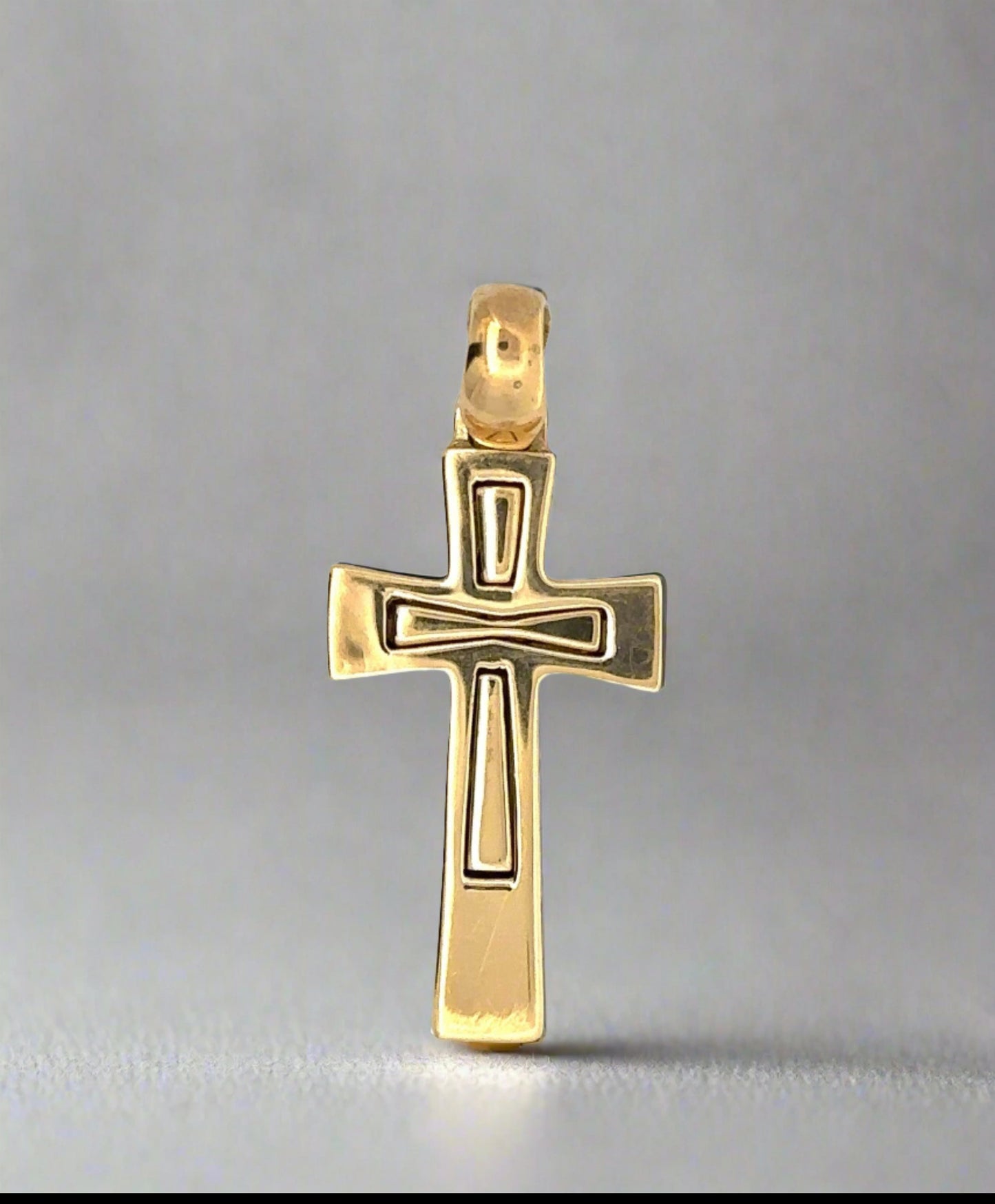 Front of yellow gold cross pendant with scratches