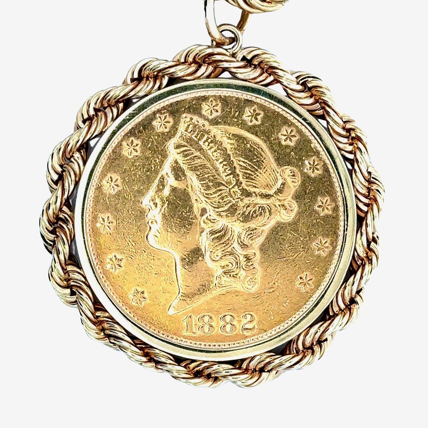 Close up of front of yellow gold coin pendant with 1882 and scratches from handling