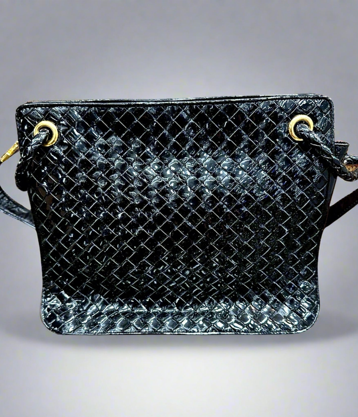Front of black patent leather bag with woven texture