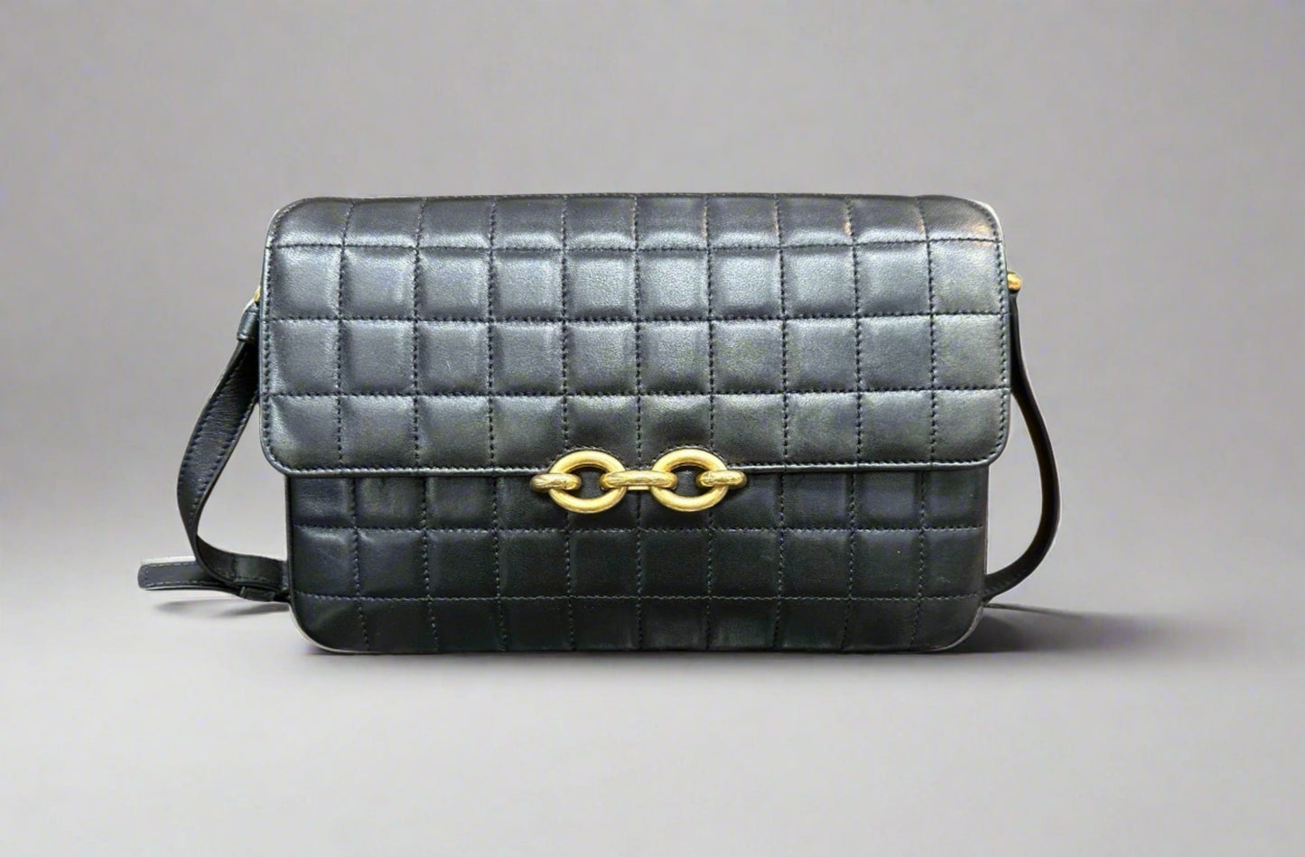 Front of black quilted Saint Laurent satchel bag with gold link closure