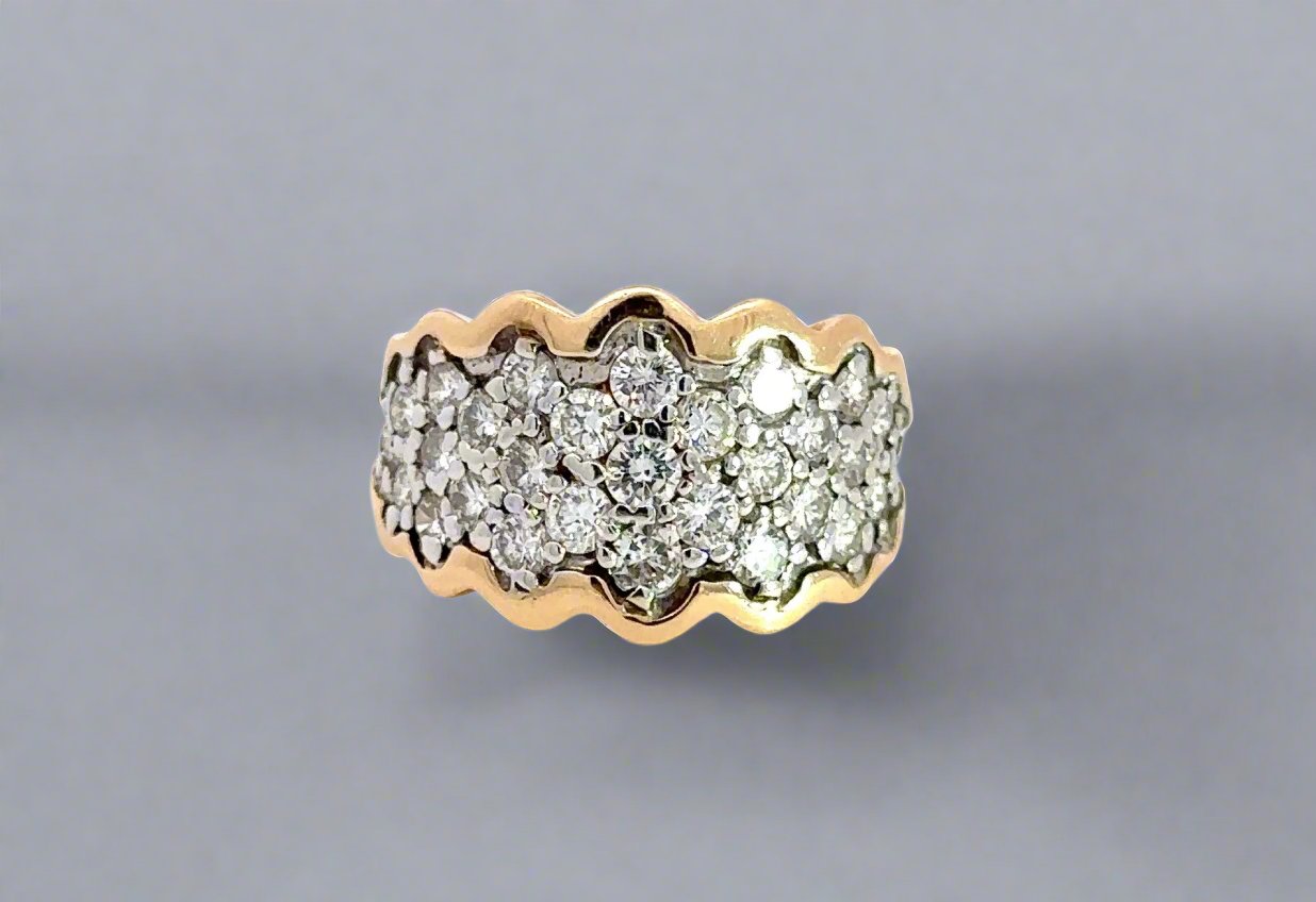 Front of diamond bang ring with a wavy gold design on the outline in yellow and white gold. Round diamonds ranging from .03-.05 carats on band