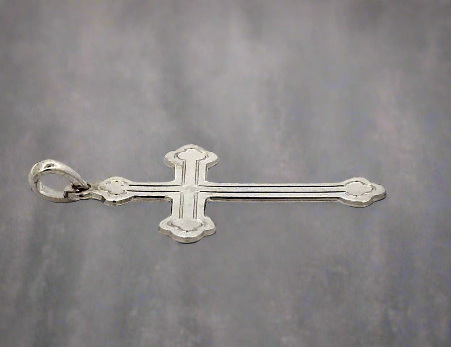 Side view of white gold cross with a small round bail