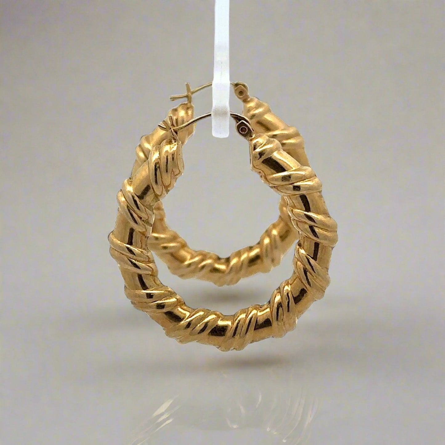 side view of yellow gold hoops with wrapped detailing