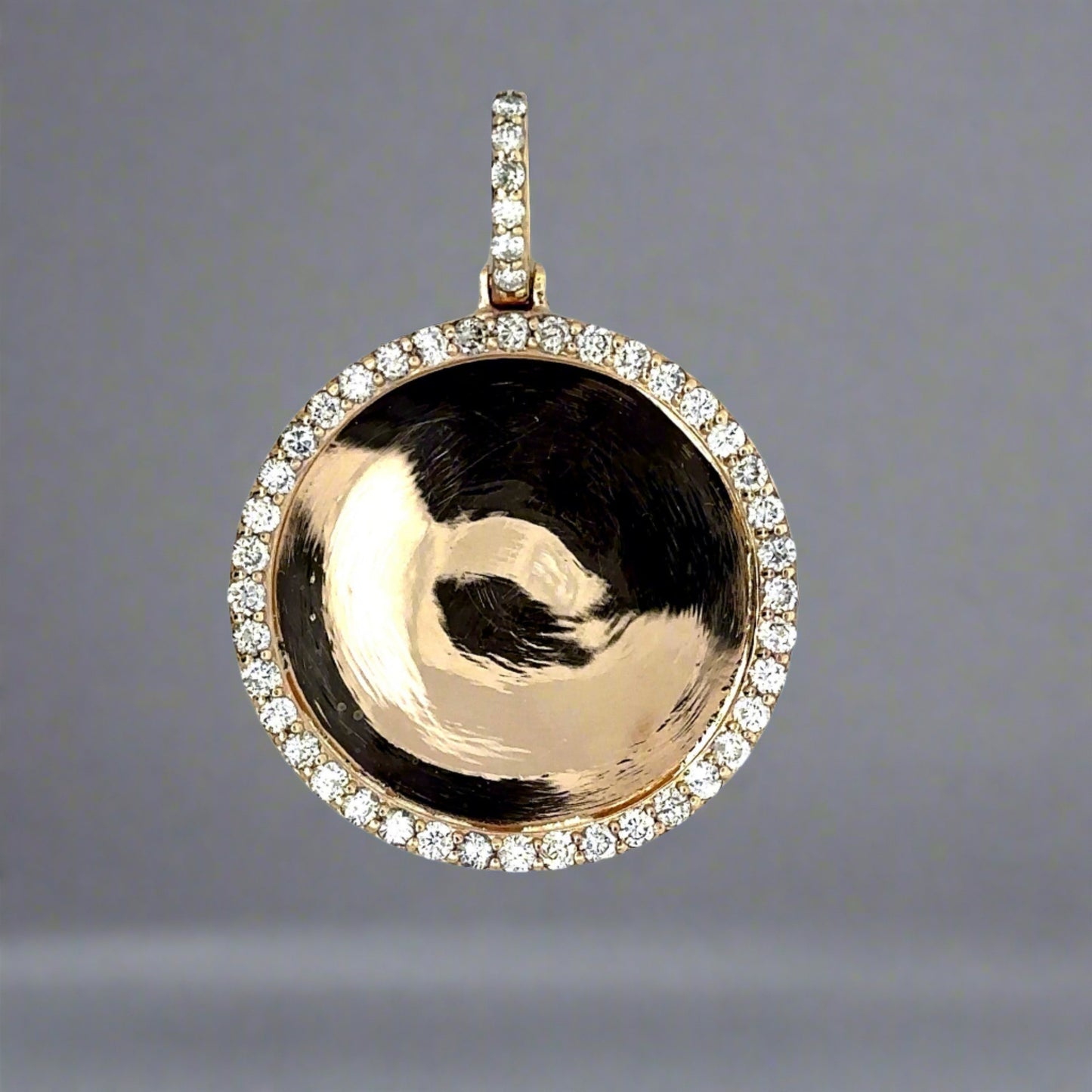 Front of round yellow gold diamond photo pendant with round diamonds around the pendant and on the bail