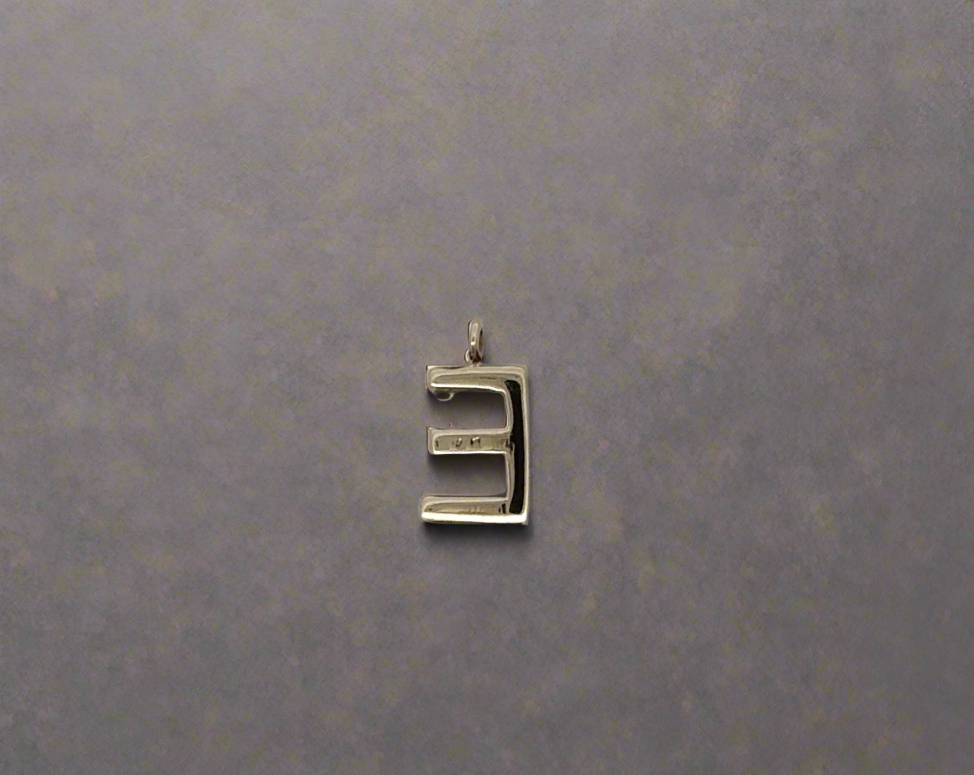 Back of E pendant with marks on back