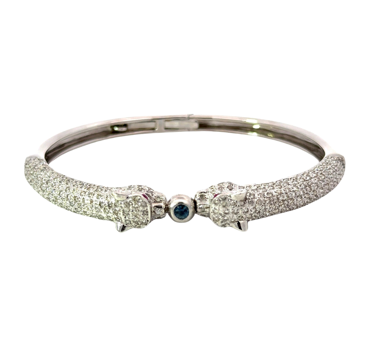 Top view of white gold bangle with diamond panthers and 1 blue gemstone for the lock