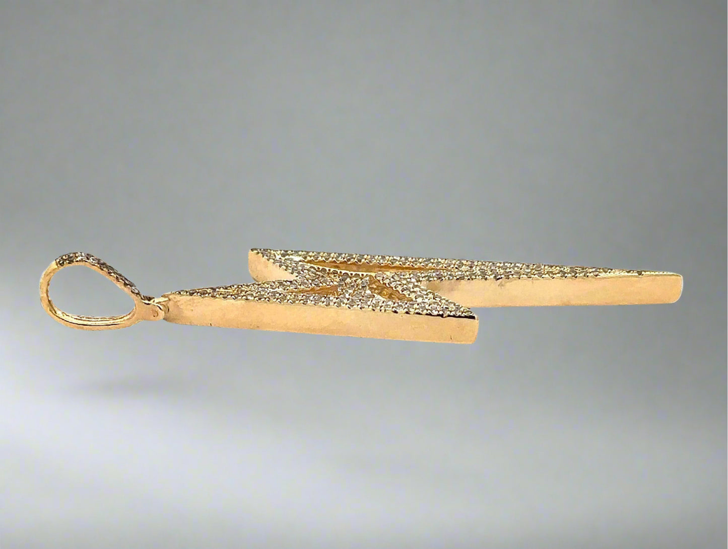Side of yellow gold pendant with faint scratches on gold