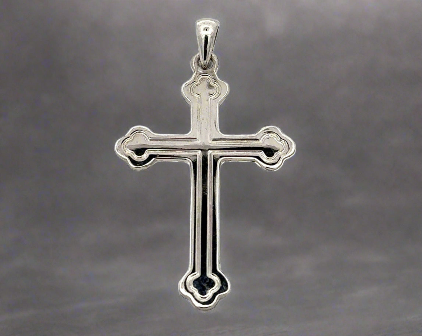 Front of white gold cross with detail lines tracing the inside. Small scratches on gold.