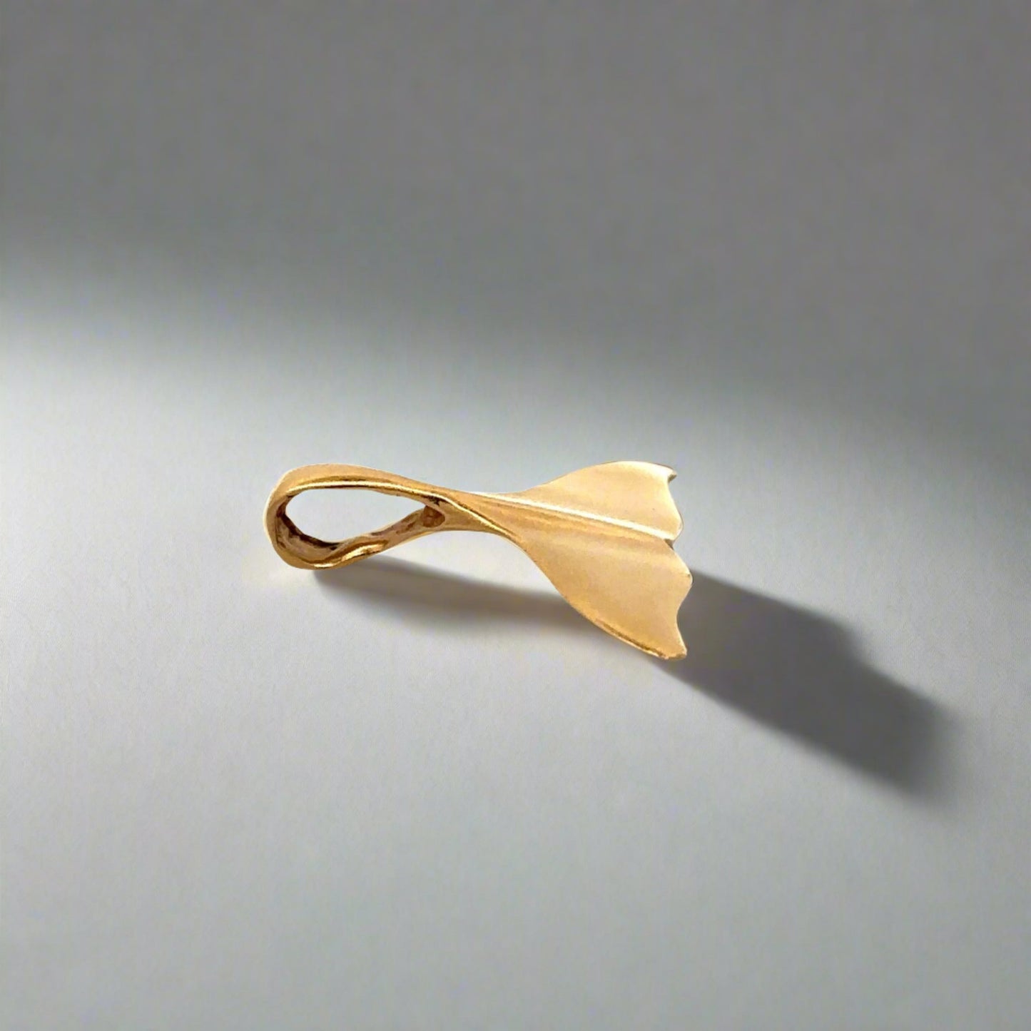 side of yellow gold whale tail pendant with small attached bail