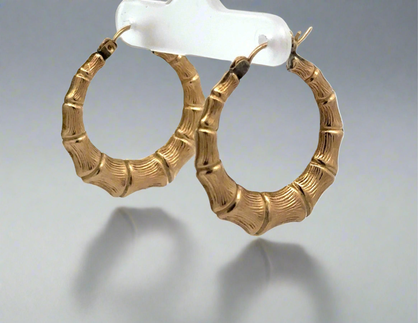 Yellow Gold Bamboo Hoop Earrings diagonal view. Discoloration at top of post that can be polished out