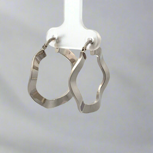 diagonal view of white gold wavy hoops