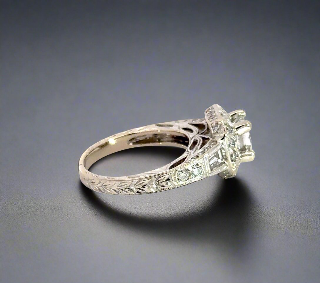Side of ring with leaf-like engraving details on band, 2 small round diamonds, and 1 baguette diamond.