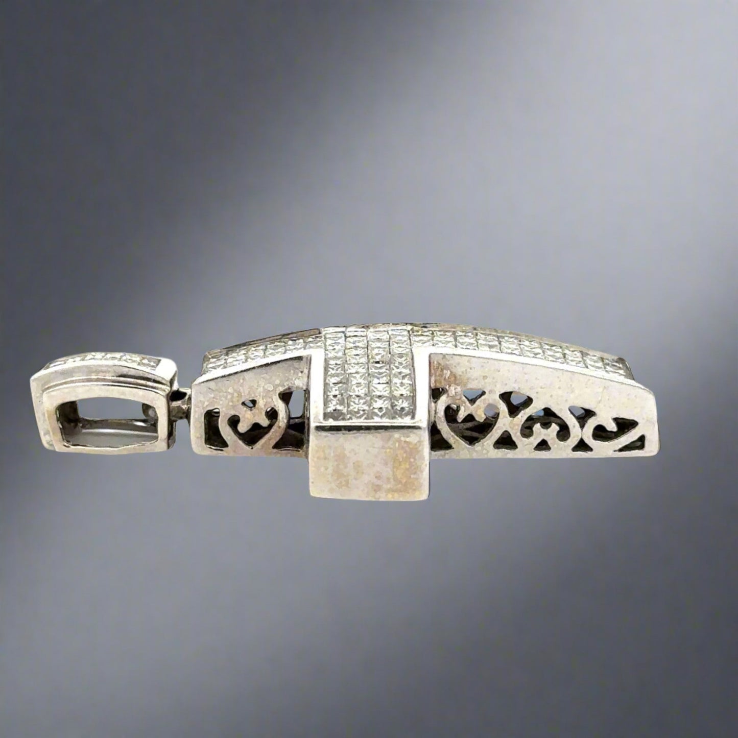 Side of white gold diamond cross pendant with marks on the gold and hearts on the side