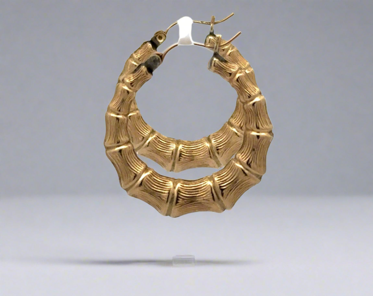 Side of yellow gold bamboo hoop earrings