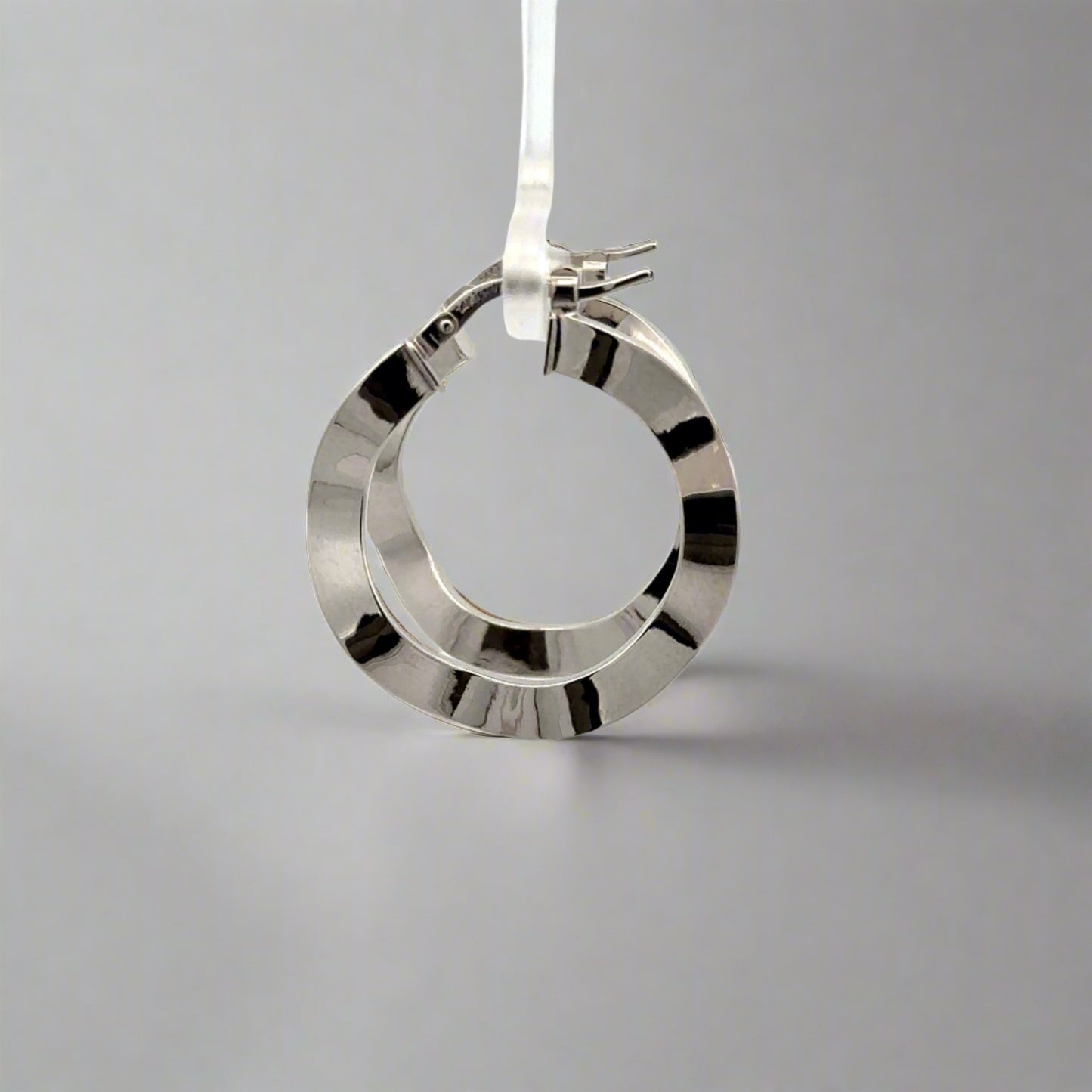 side of white gold wavy hoops