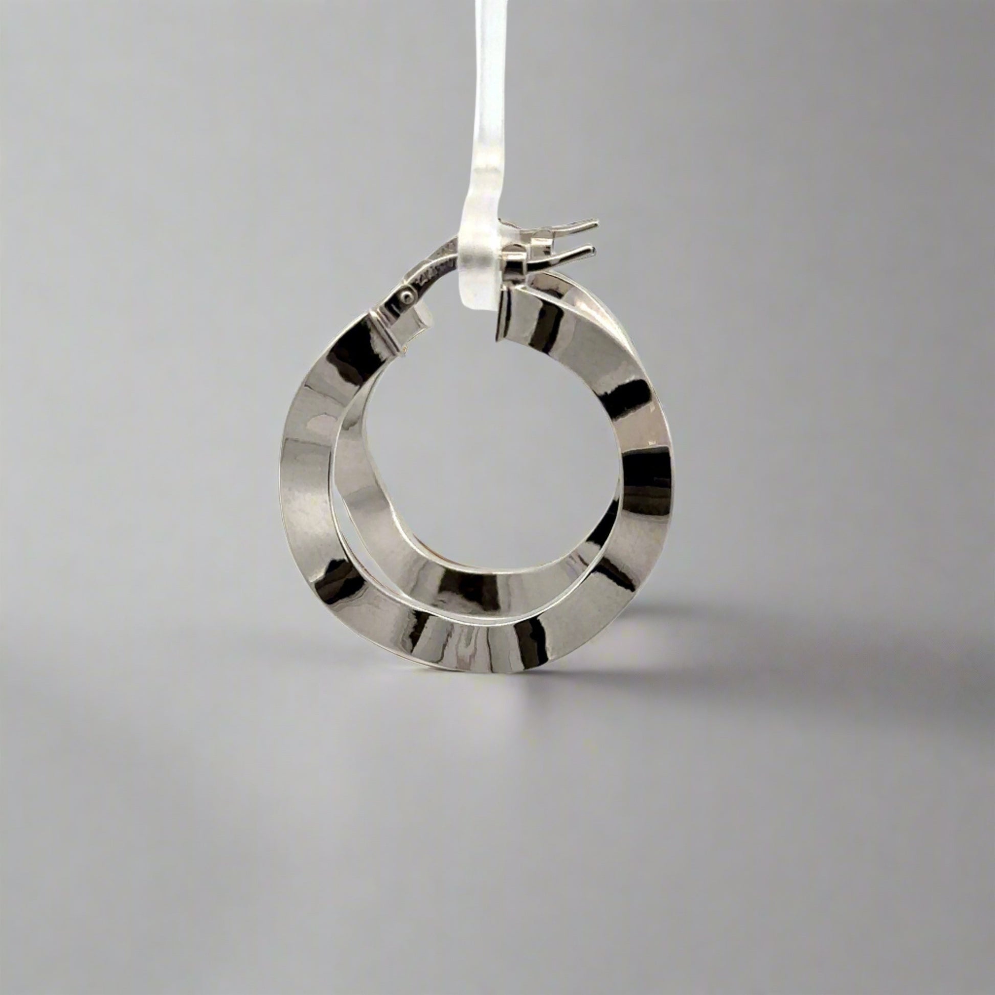 side of white gold wavy hoops