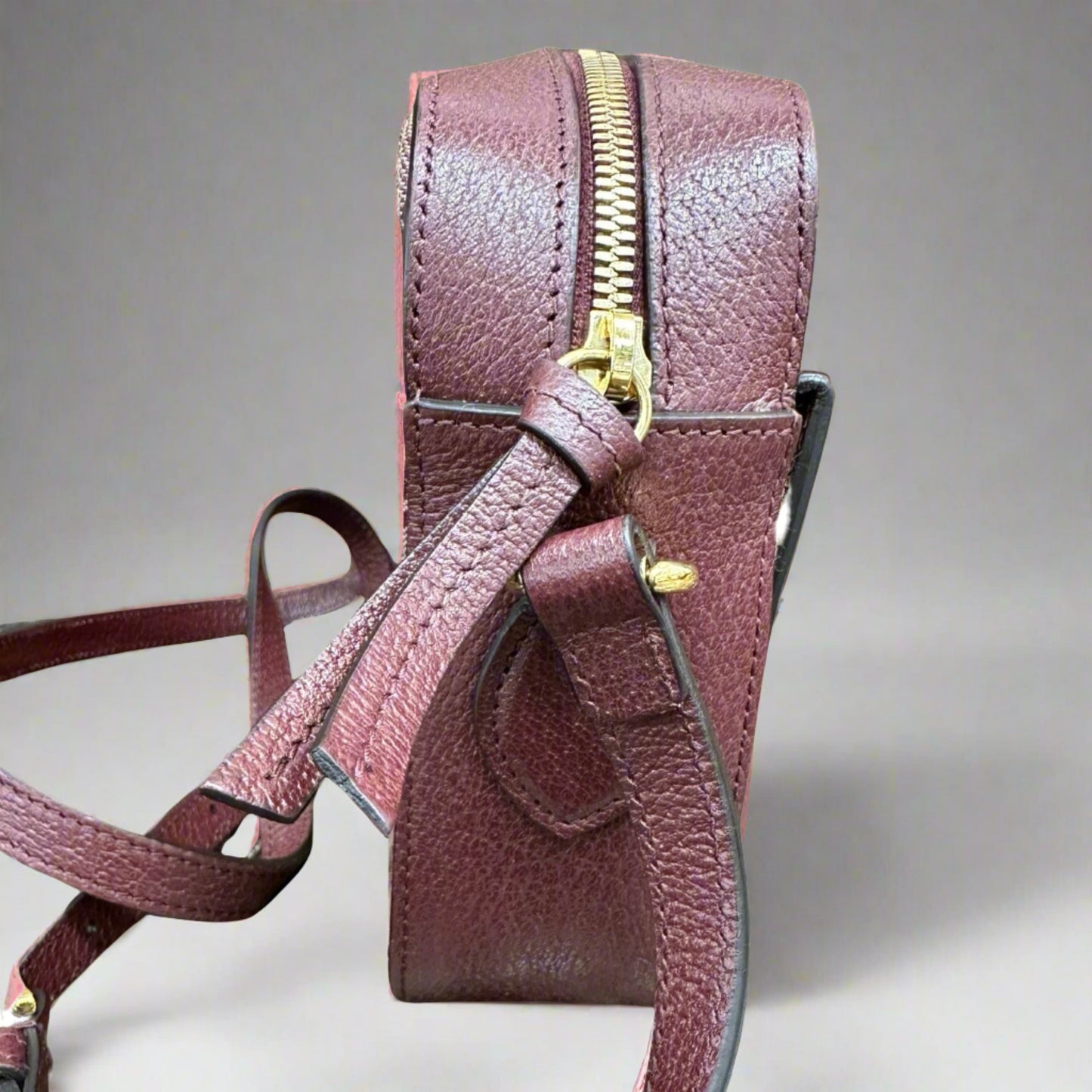Side of bag with Burgundy leather and gold hardware
