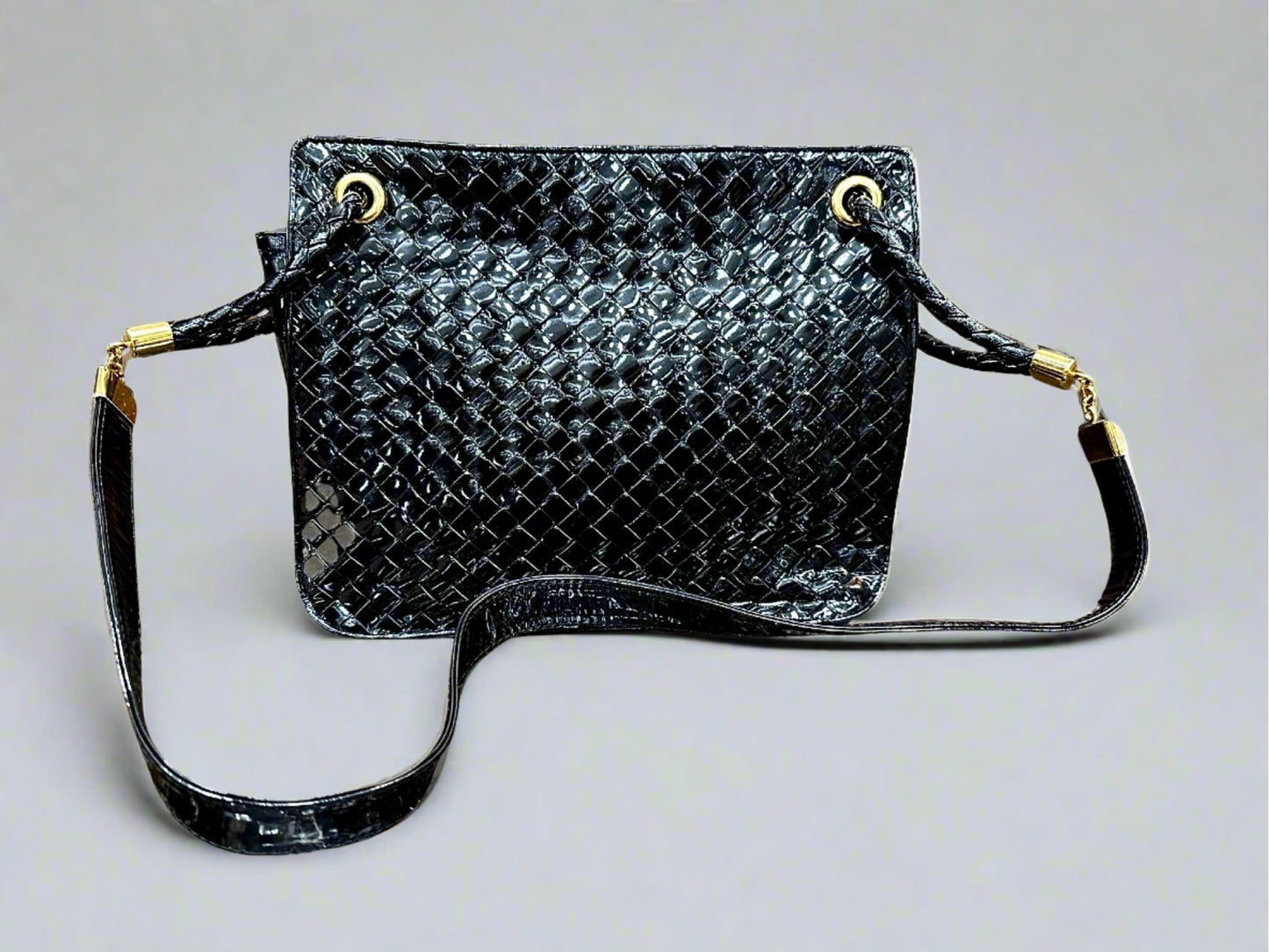 Black patent leather bag with misshaped shoulder strap