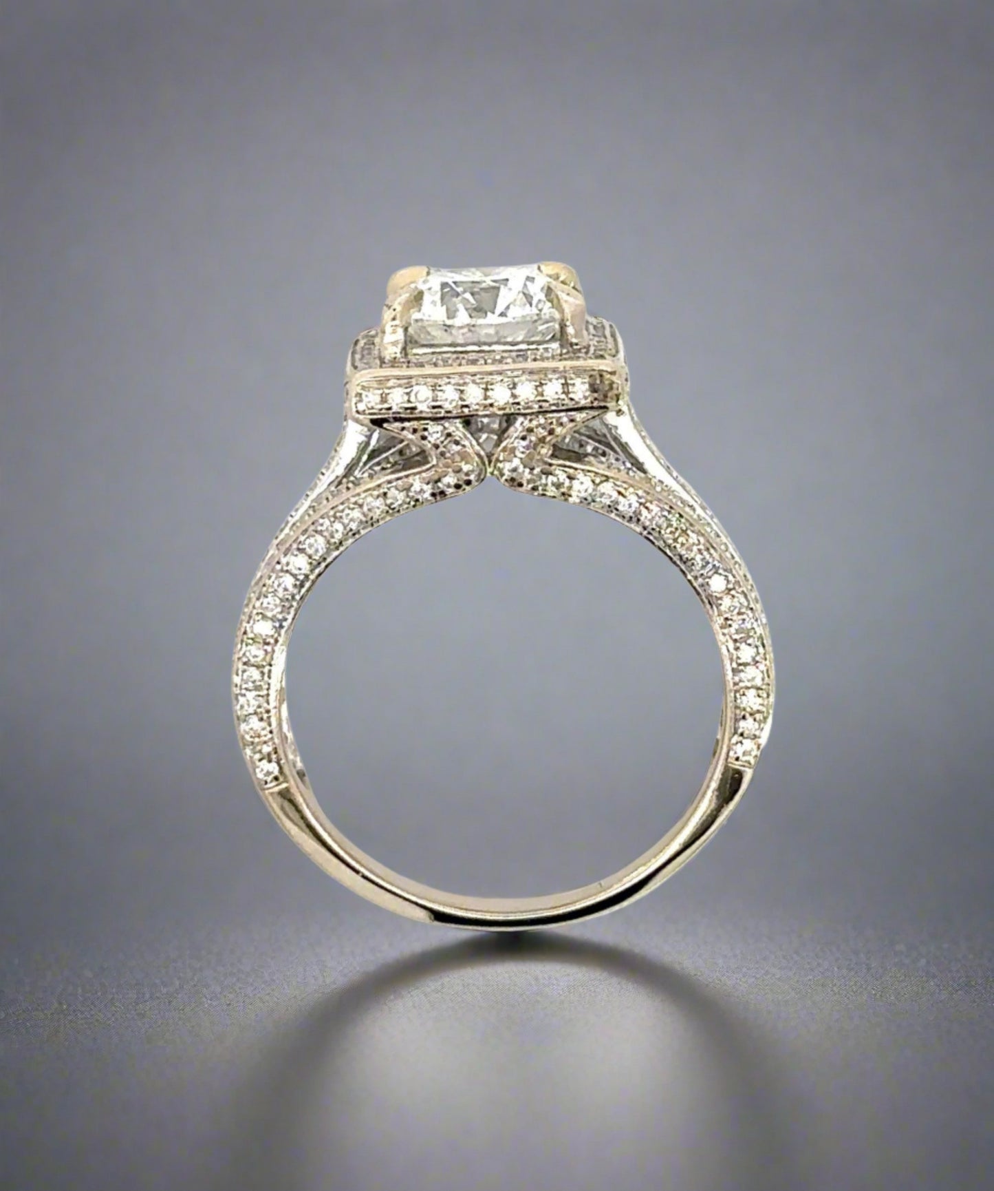 top of the side of the ring showing diamonds on the prongs, on side of band, and around center stone