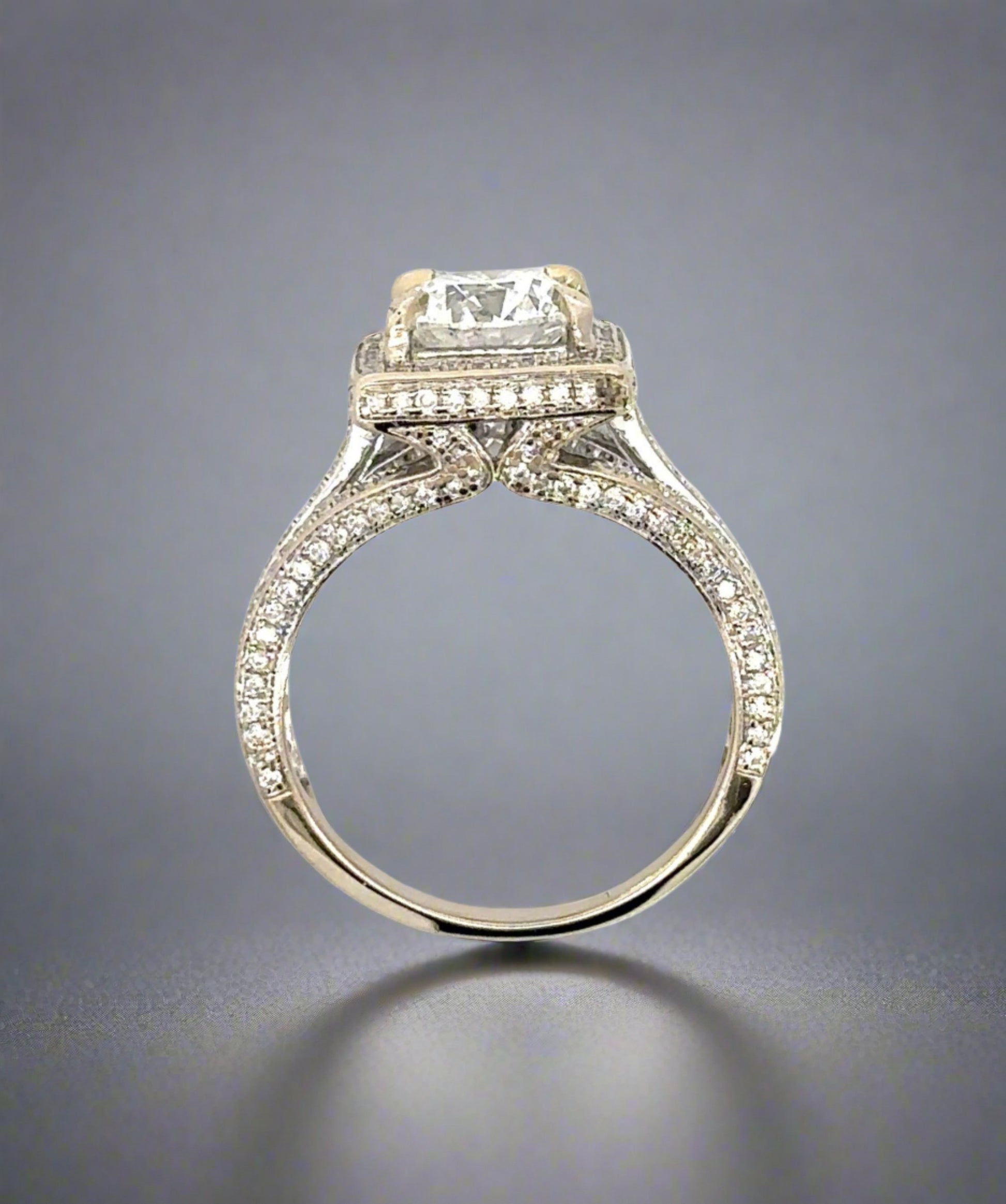 top of the side of the ring showing diamonds on the prongs, on side of band, and around center stone