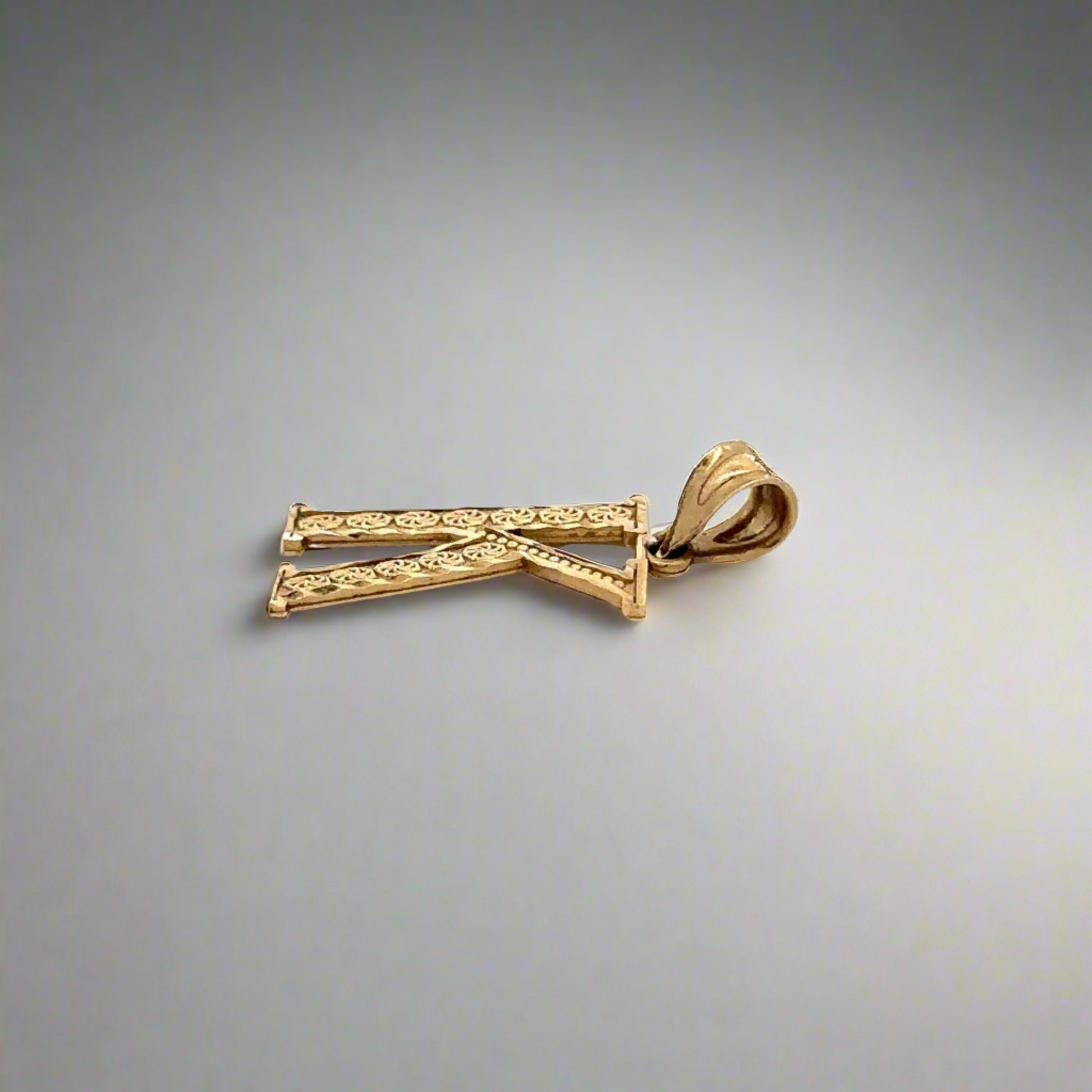 side of yellow gold k pendant with round bail