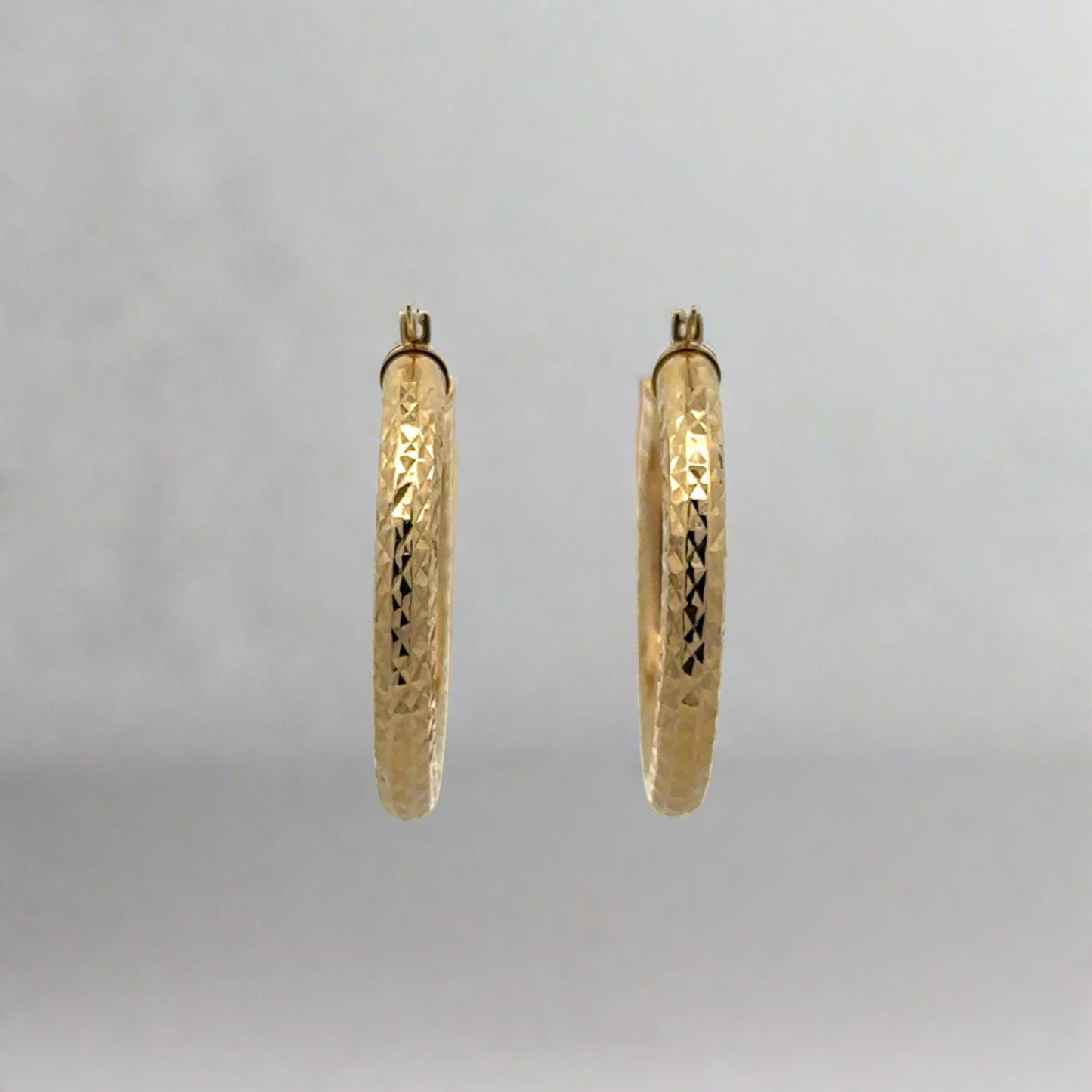 Front of yellow gold textured and polished hoops