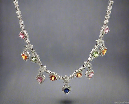 hanging white gold diamond necklace with 4 pink heart-shaped stones, 4 orange heart shaped stones, 2 green heart shaped stones, and 1 centered blue heart shape stone