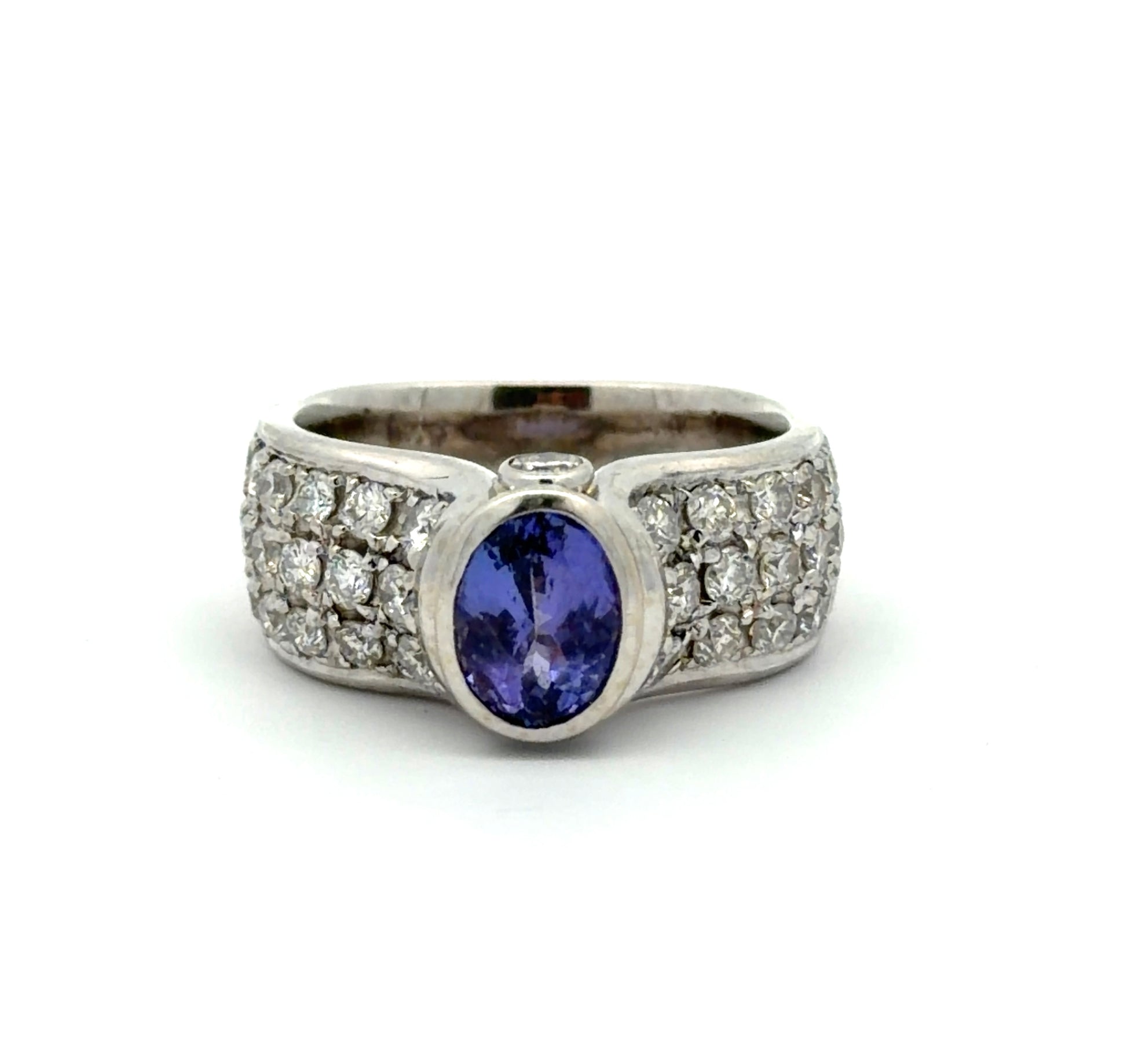 White gold ring with a Tanzanite oval gemstone and diamond accents on a white background