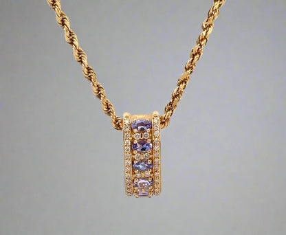 front of yellow gold rope chain and yellow gold diamond and gemstone pendant