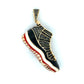 Shoe-shaped pendant with black and red design on a white background