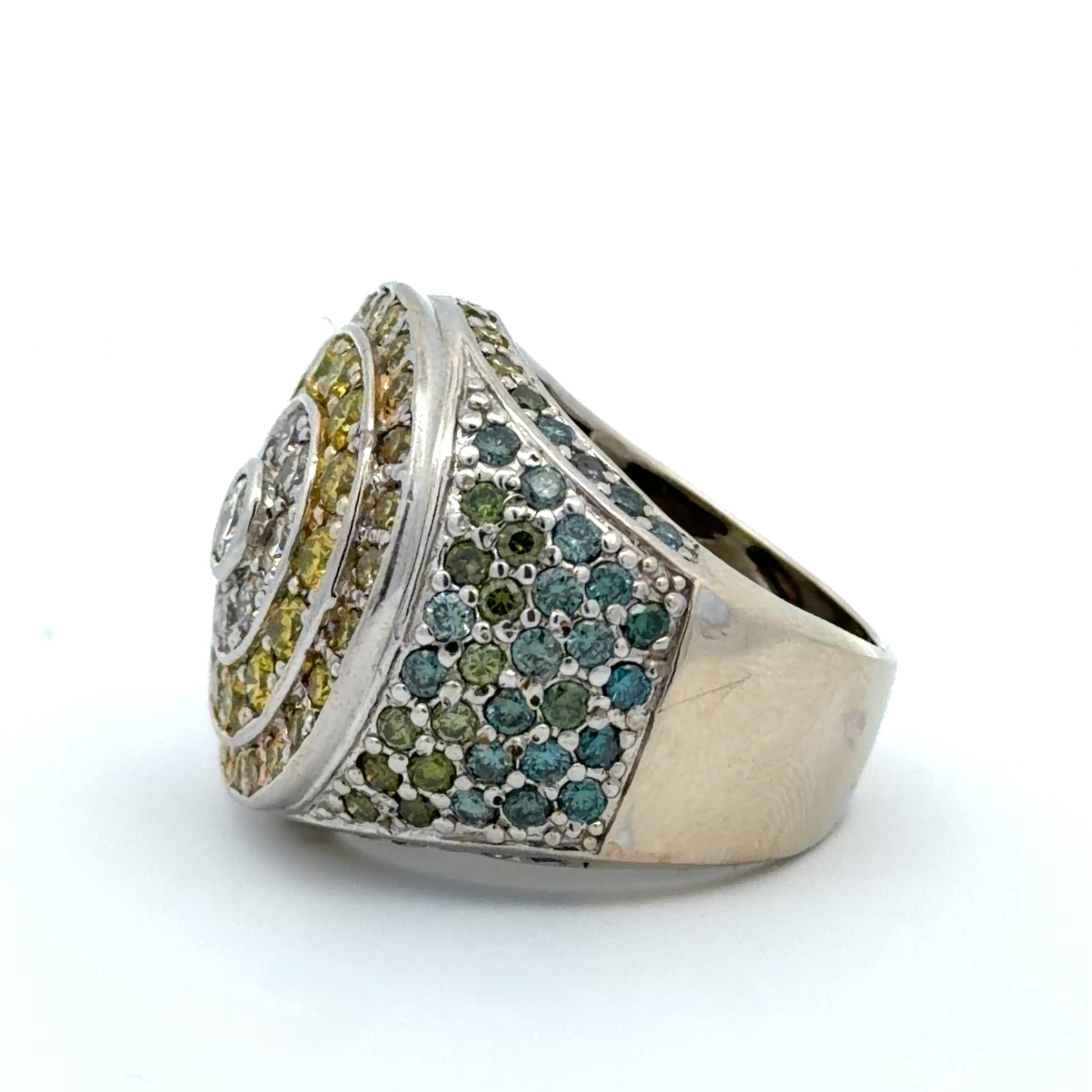 White gold ring with yellow, white, blue, & green diamonds on a white background