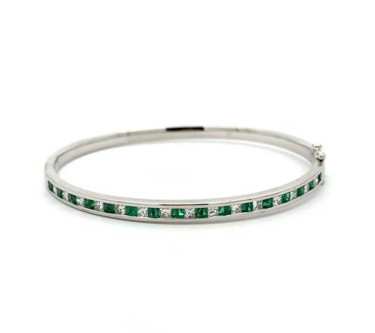 White gold princess-cut diamond and emerald bangle bracelet on white background