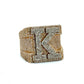 Gold ring with diamond accents and the letter 'K' on a white background