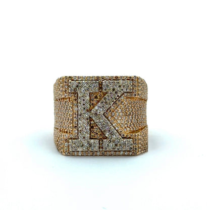 Gold and diamond-encrusted ring with a prominent 'K' on a white background