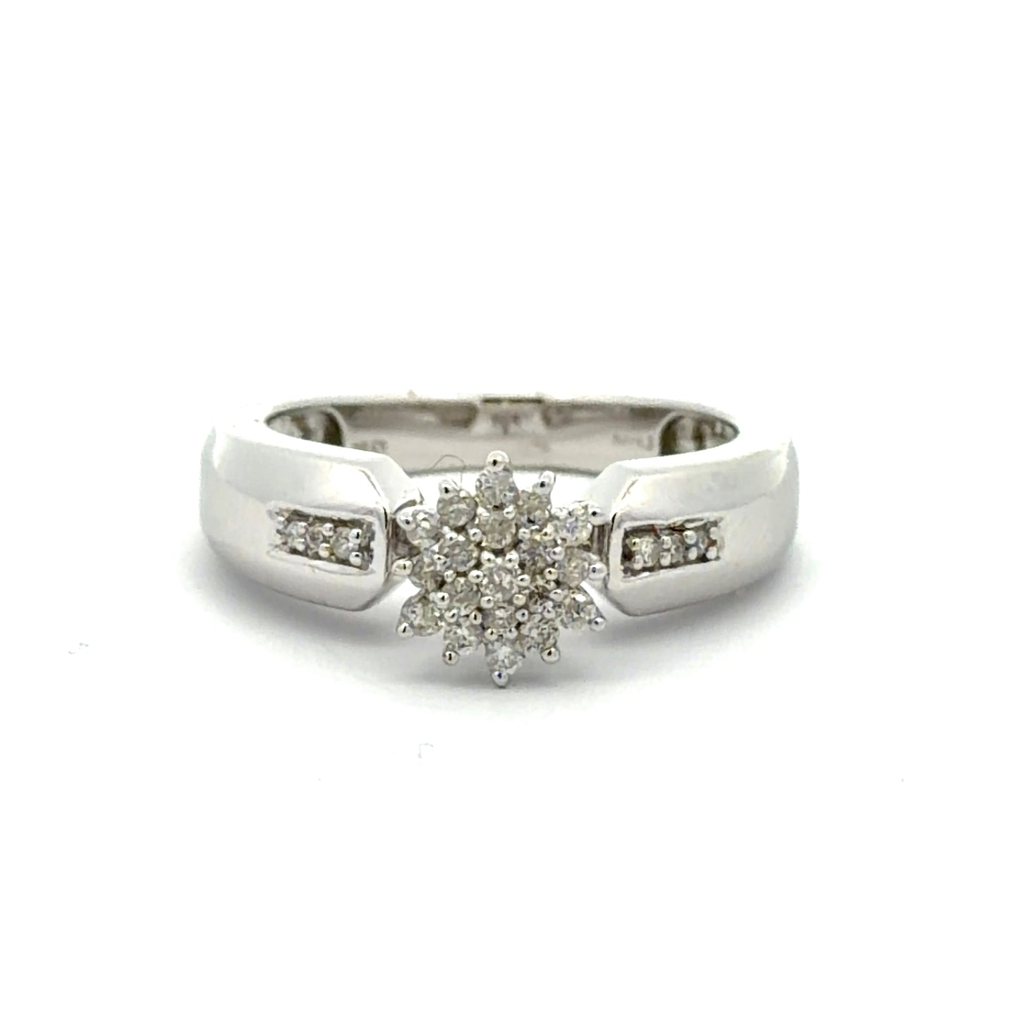 White gold ring with a diamond flower design on a white background