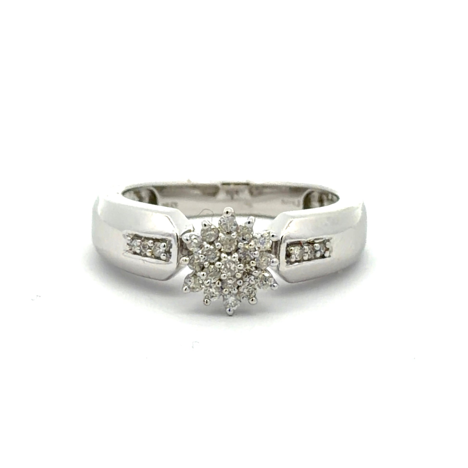 White gold ring with a diamond flower design on a white background