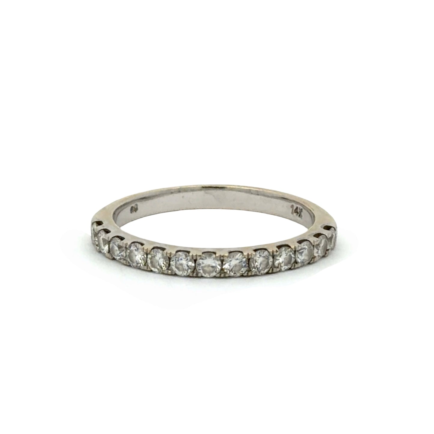 A white gold band ring with round diamonds on a white background