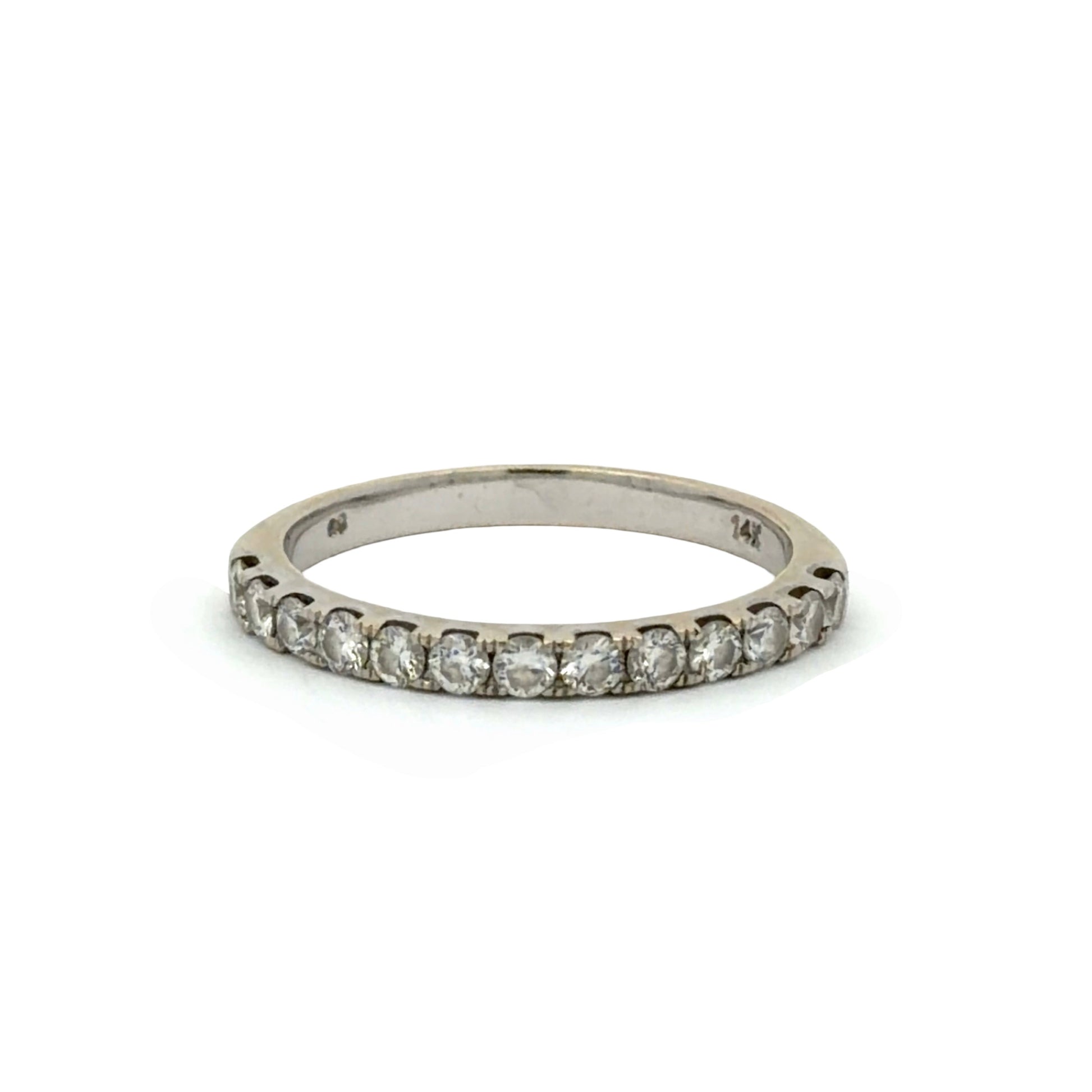 A white gold band ring with round diamonds on a white background