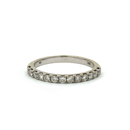 A white gold band ring with round diamonds on a white background