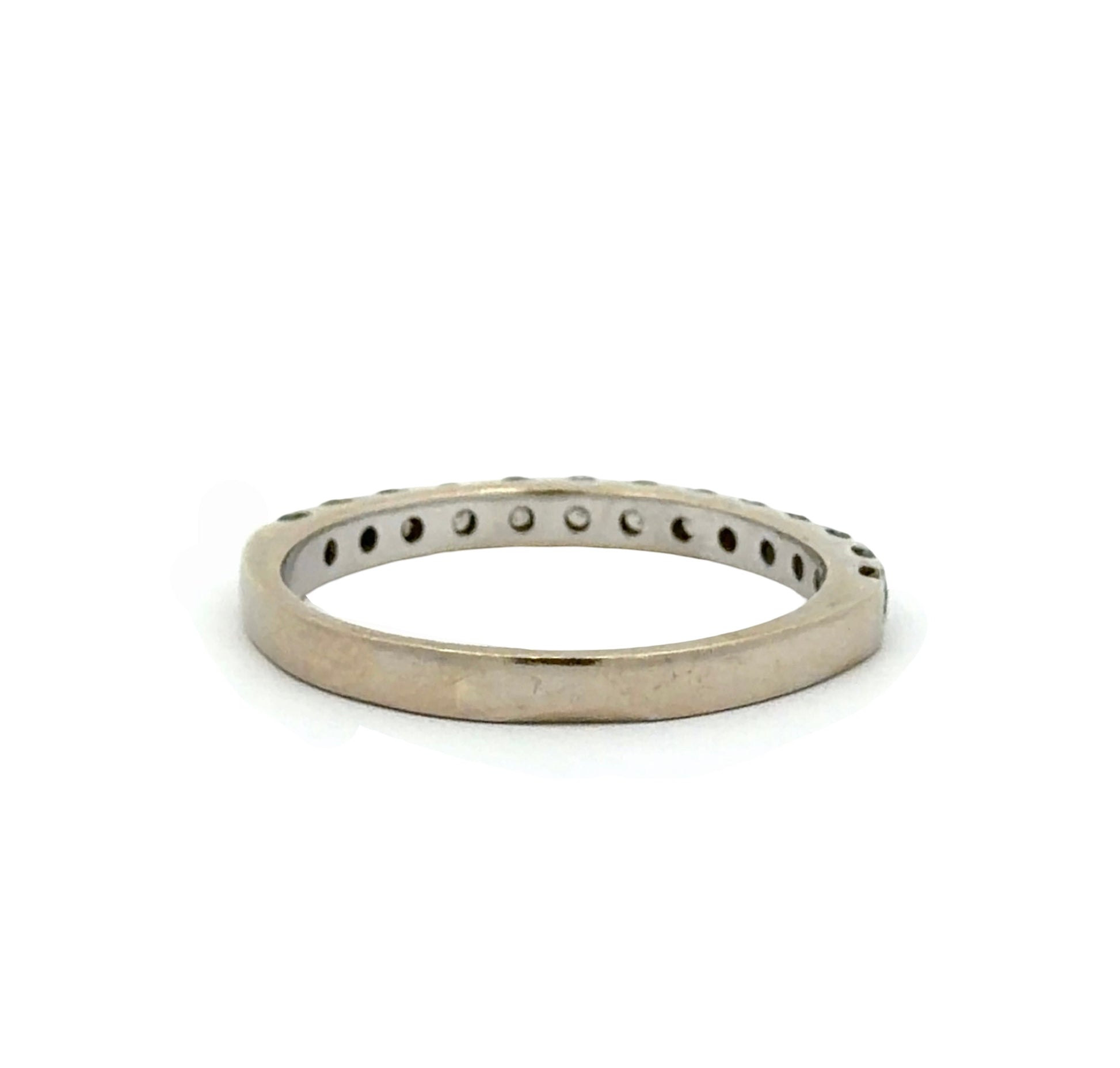Back of a white gold diamond band ring with diamonds on half of the band. Scratches and a little yellow tint shown on gold.