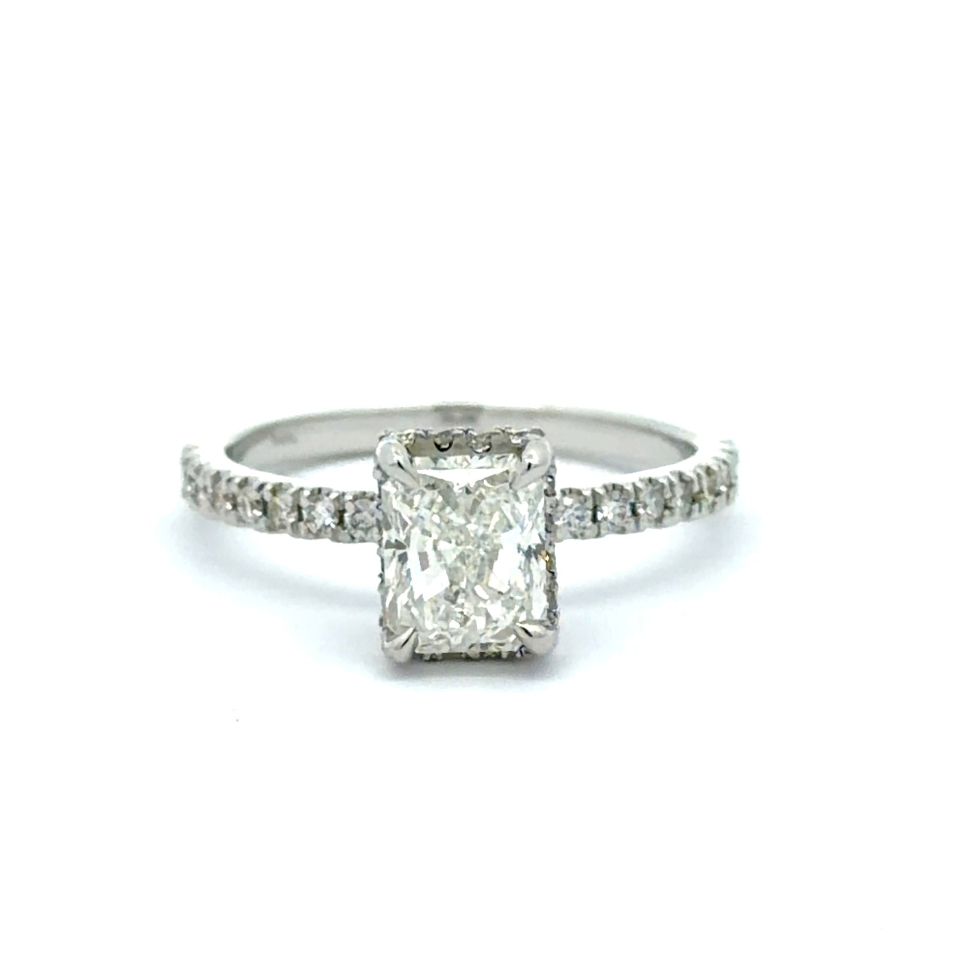 Diamond ring with a rectangular center stone on a white background