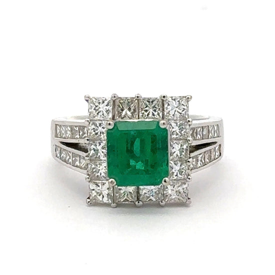 Ring with a green gemstone and diamond accents on a white background