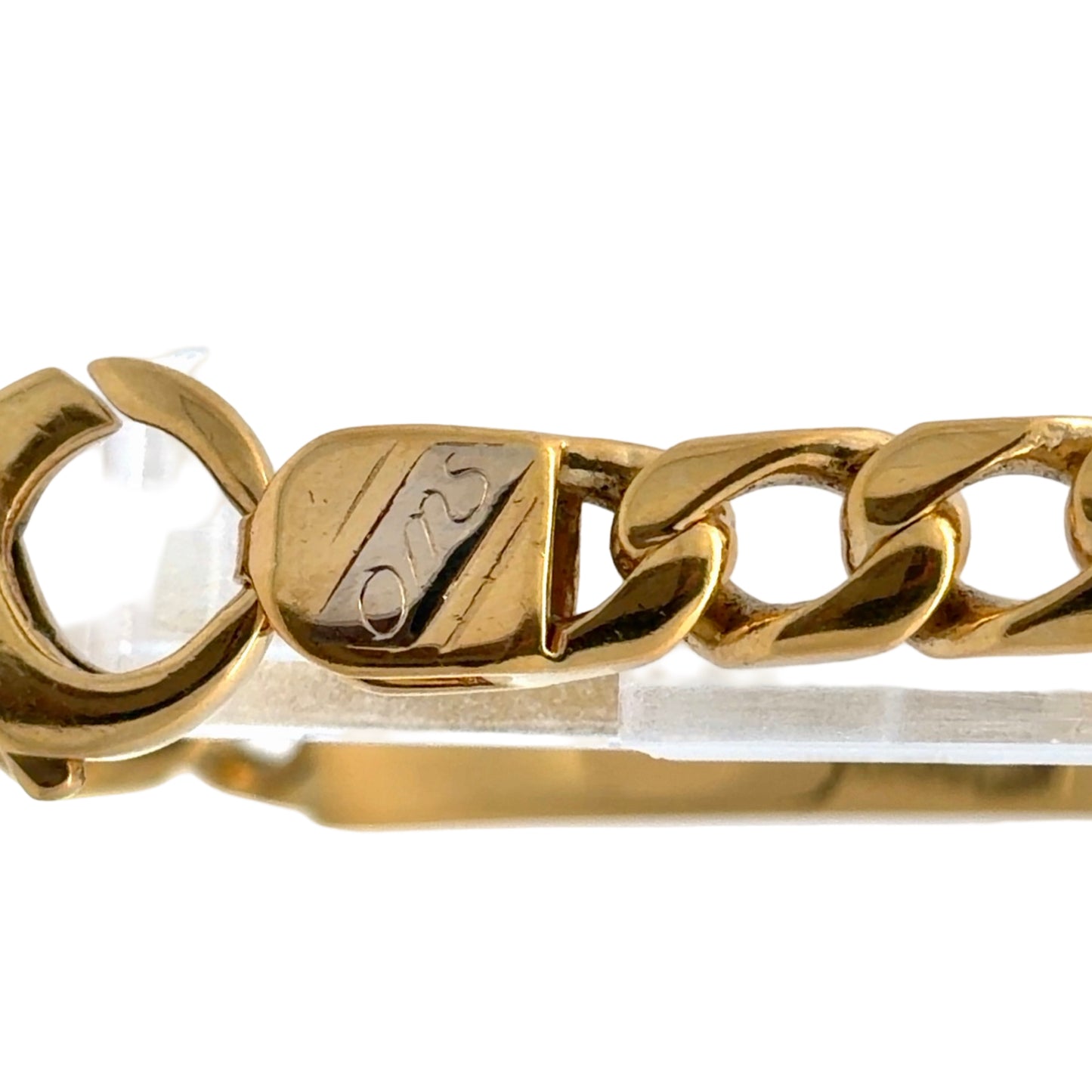 Close up of OMS engraved on a small piece of white gold on the link 