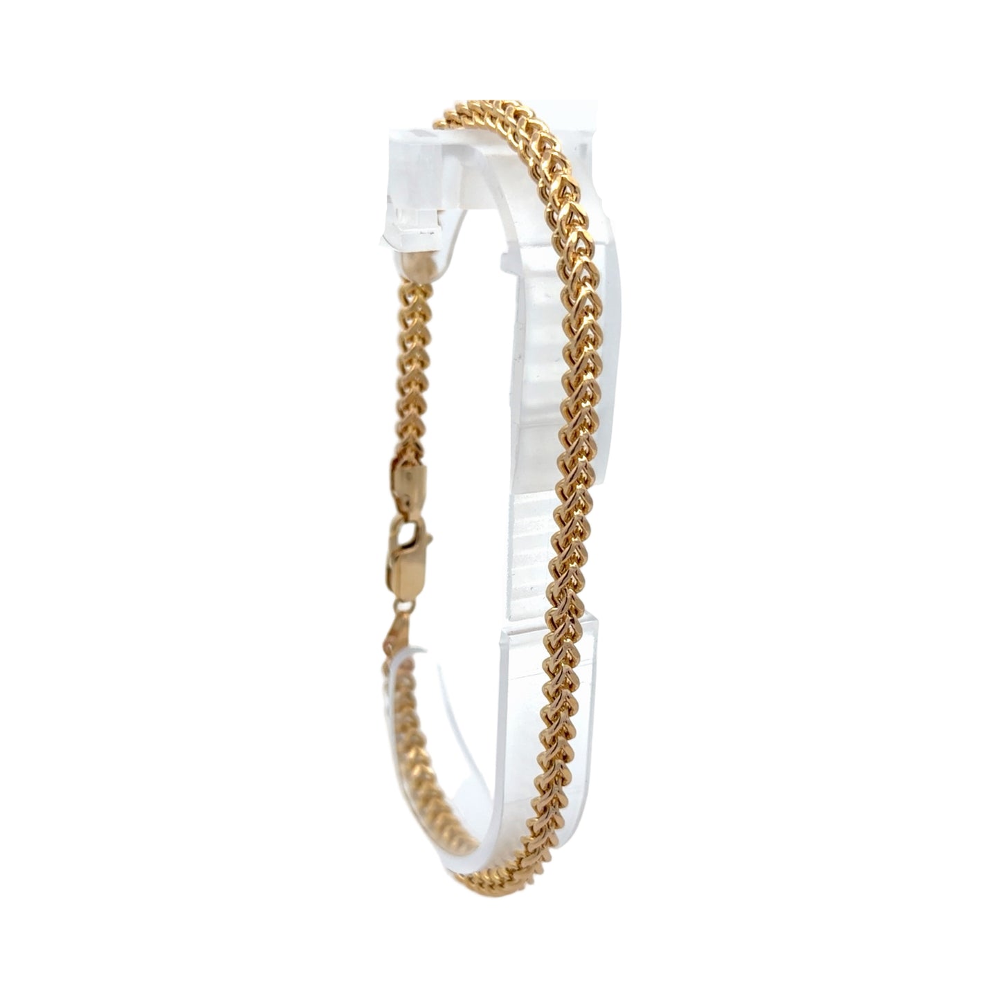 A gold-toned anklet displayed on a clear plastic hanger against a plain white background.