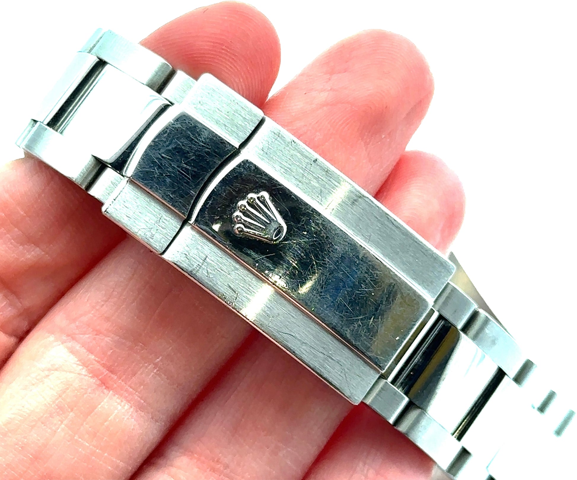 Close-up of a silver watch band with a visible brand logo on a hand.