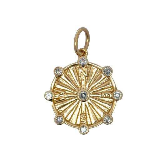 Gold compass pendant with diamond accents on a white background